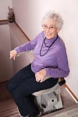 93 year old woman using stair lift in her home