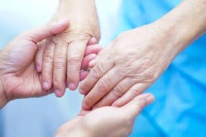 Caregiver holding hands with resident