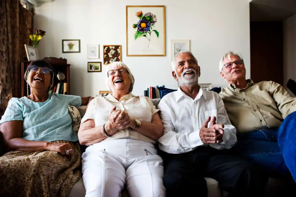 Group Of Senior Friends Sitting And Watching Tv Together