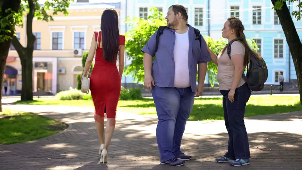 Fat man admires slim woman