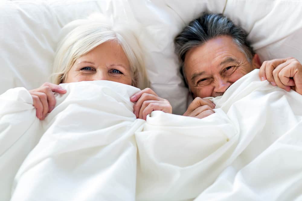 Senior couple under the sheets